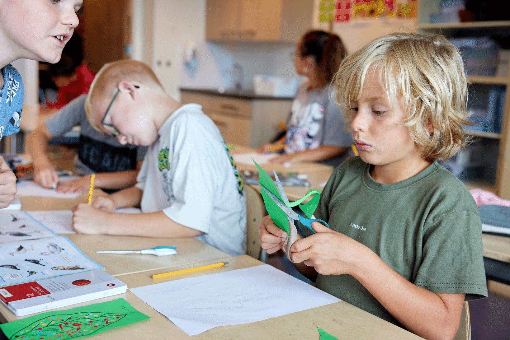 Een leerling knipt een figuur uit papier