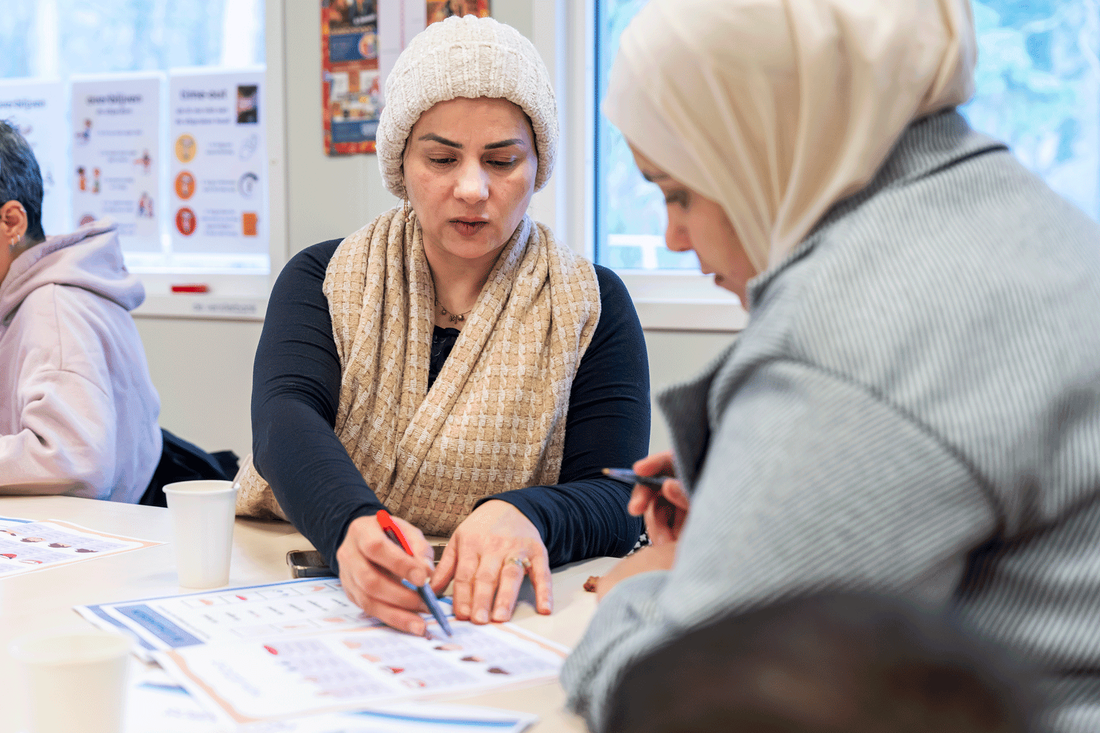 Twee ouders kijken samen naar een opdrachtenboek