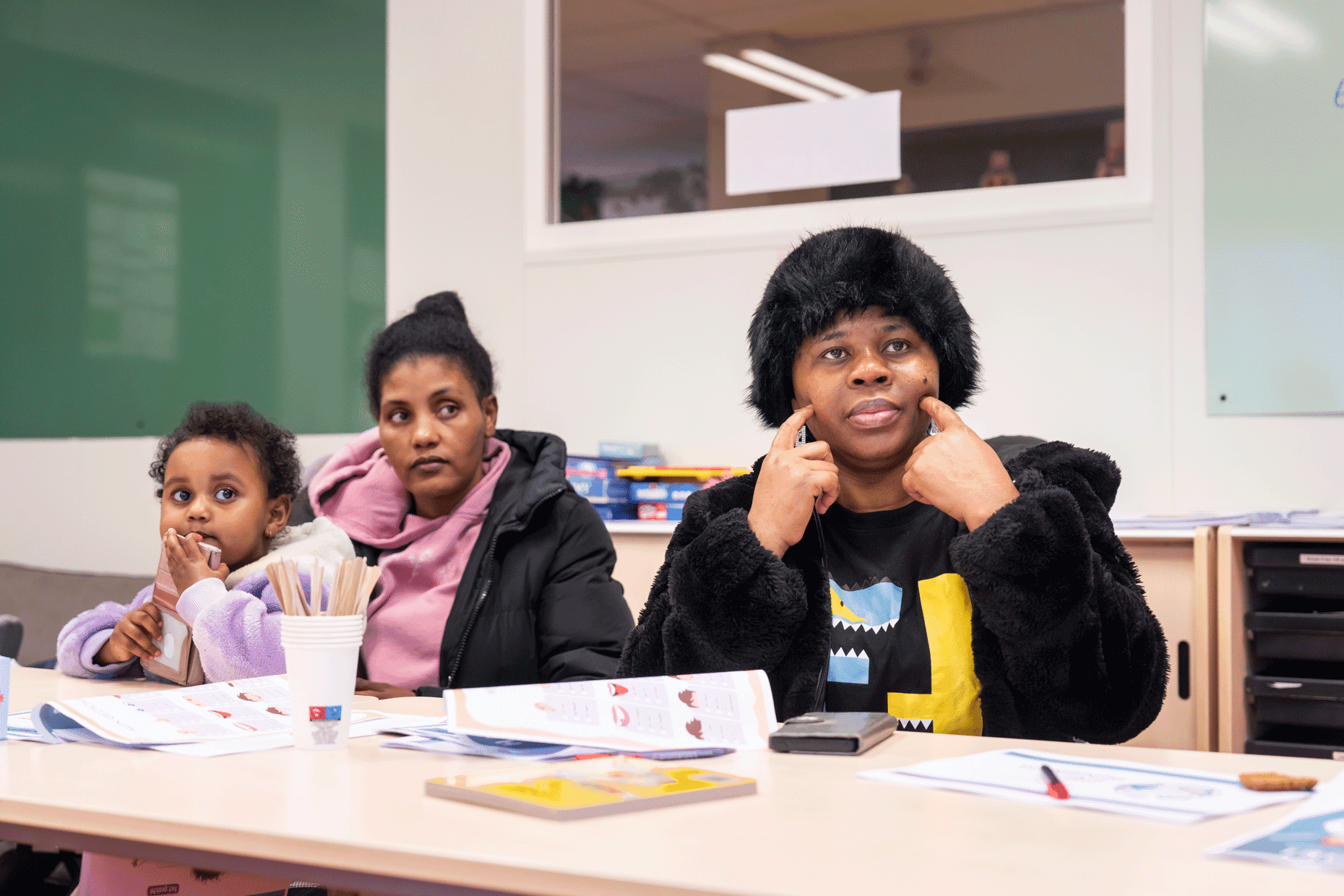 Ouders en kinderen zitten samen in het lokaal