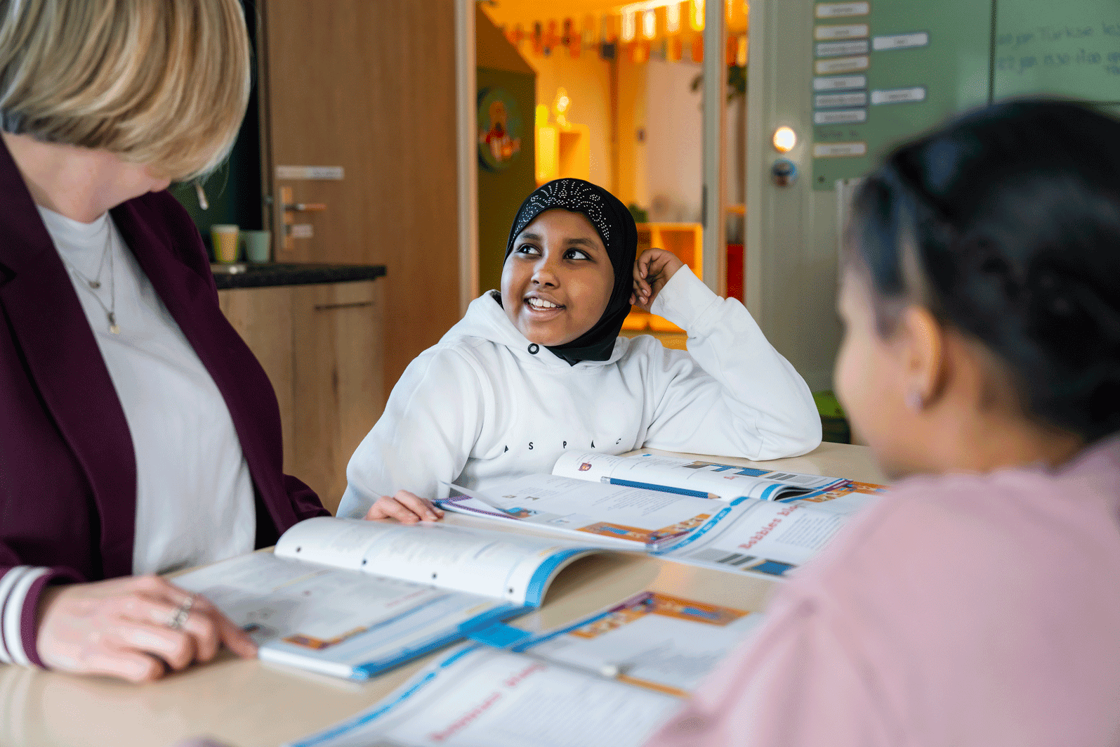 Twee leerlingen krijgen persoonlijke instructie van leraar