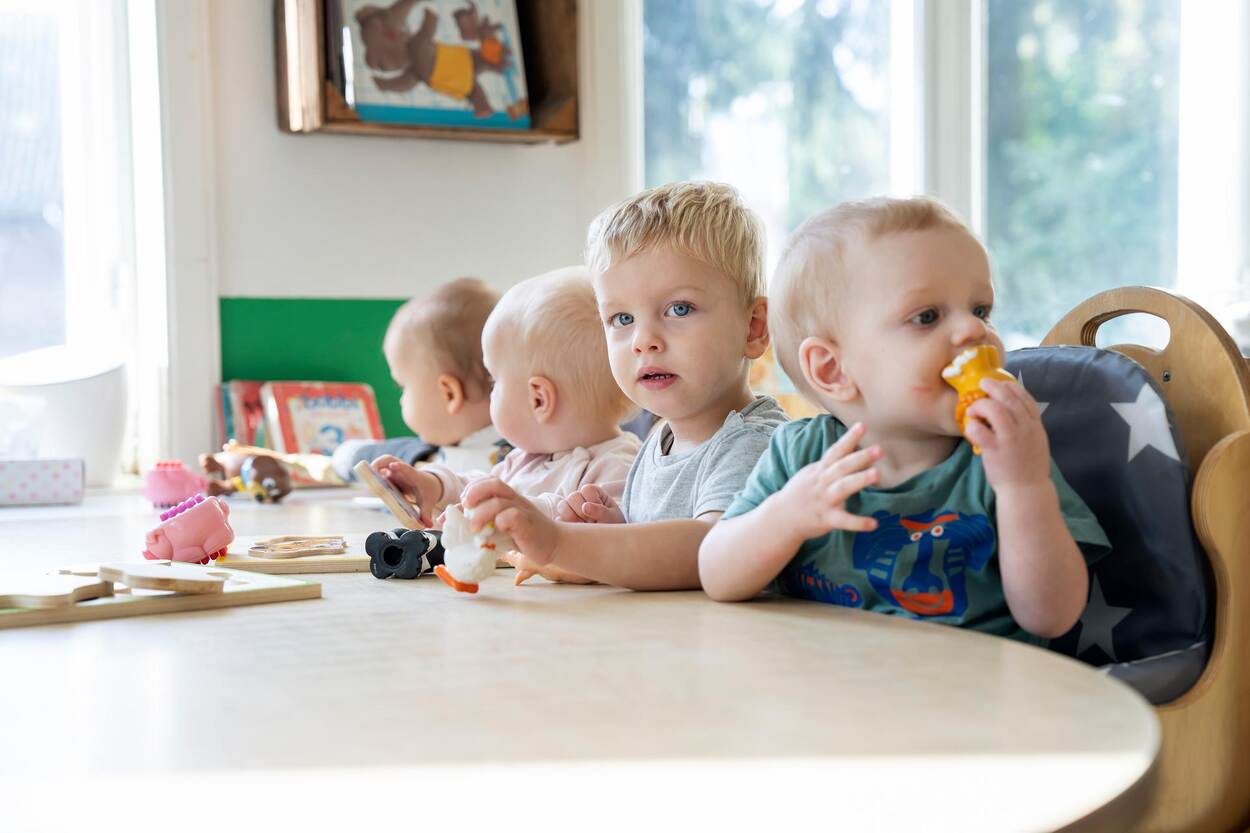4 kindjes eten naast elkaar aan tafel