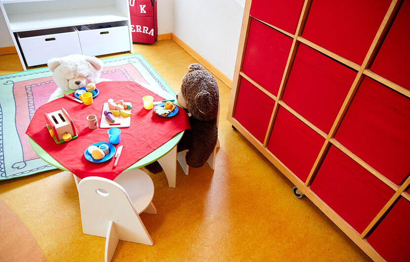 Kindertafeltje gedekt met kinderservies, aan tafel zitten 2 knuffelberen