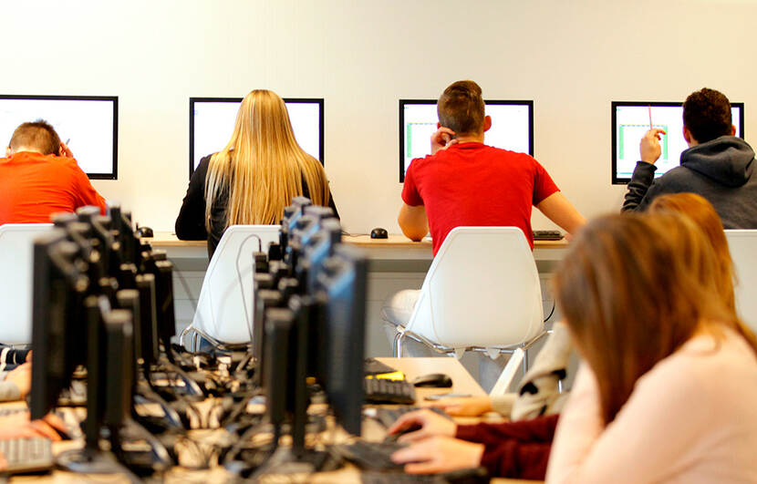 Leerlingen in een klas achter een computen